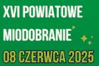 Biay napis 'XVI Powiatowe Miodobranie' na zielonym tle
