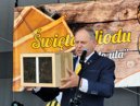 Jarek Wasiak z pakietem pszcz na tle banneru imprezy "Jak Pszczoy do Ula"